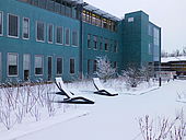 Verschneites Außengelände mit dem blauen Gebäude im Hintergrund